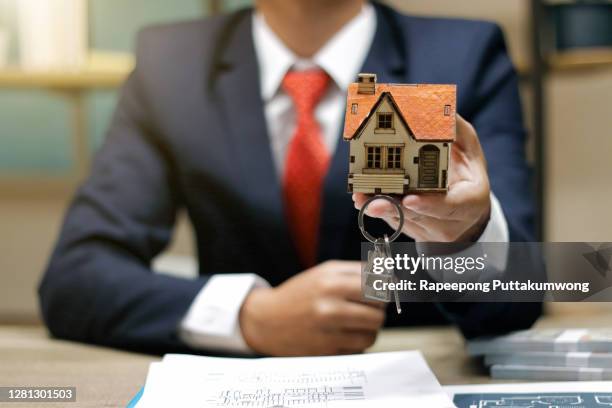 real estate broker agent with house model and keys - mortgage agreement stock pictures, royalty-free photos & images