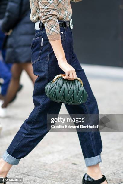 Guest wears a green woven leather Miu Miu bag, blue hem jeans, outside Miu Miu, during Paris Fashion Week - Womenswear Spring Summer 2021, on October...