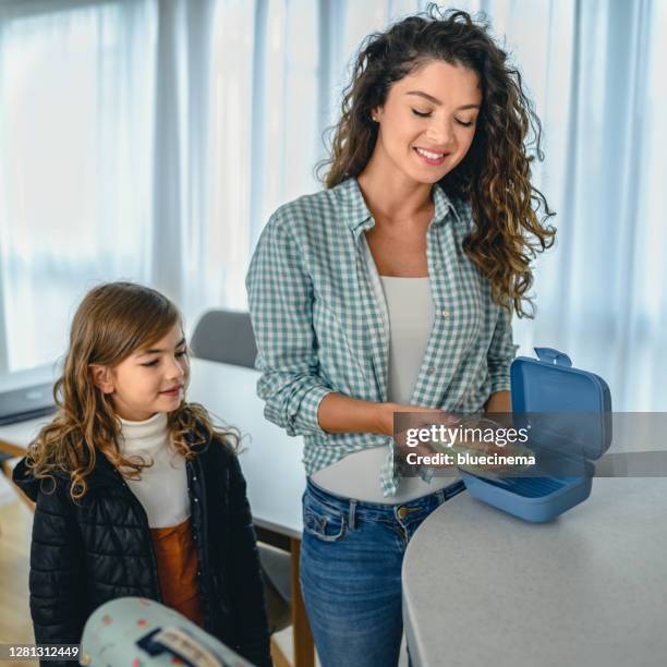 het kind dat van de school lunchdoos van haar moeder neemt - schoolbag lunchbox lunch stockfoto's en -beelden