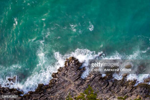 top down view of sicilian rocky coast with blue water of tyrrhenian sea near cefalu, sicily, italy - roccia foto e immagini stock