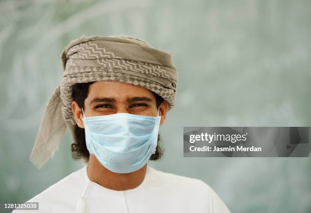 young middle eastern man with face mask - united arab emirates university stock pictures, royalty-free photos & images