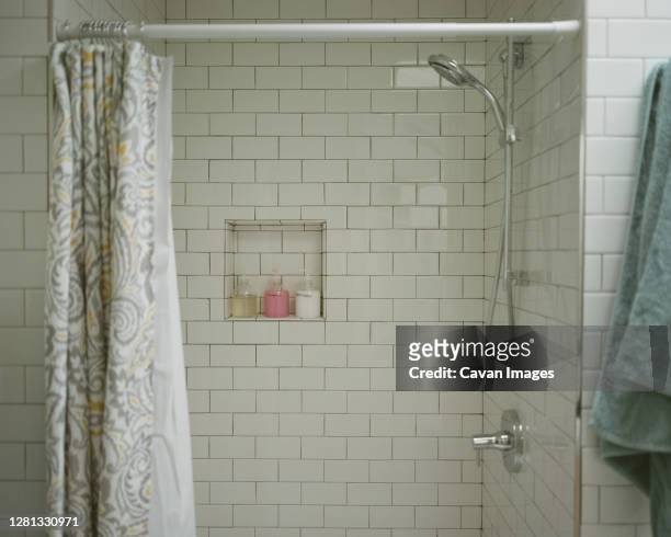 tiled shower in vacation rental company vacation bathroom with green towel and soap - bath shower stock pictures, royalty-free photos & images
