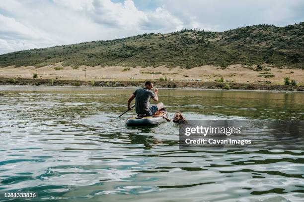 father and daughter playing with a paddle board on a lake - denver summer stock pictures, royalty-free photos & images