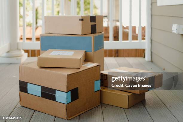 stack of packages on front porch after mail delivery - veranda stock pictures, royalty-free photos & images