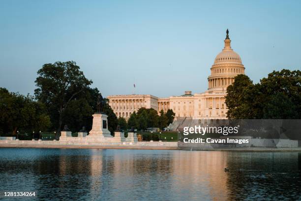 view of the us capitol building across reflecting pool - reflecting pool stock pictures, royalty-free photos & images