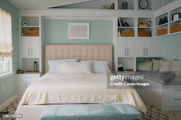 bright bedroom interior with built in bookshelves and bench - headboard ストックフォトと画像