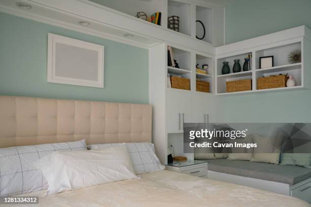 clean modern bedroom with display shelves and reading nook bench - nook architecture stockfoto's en -beelden