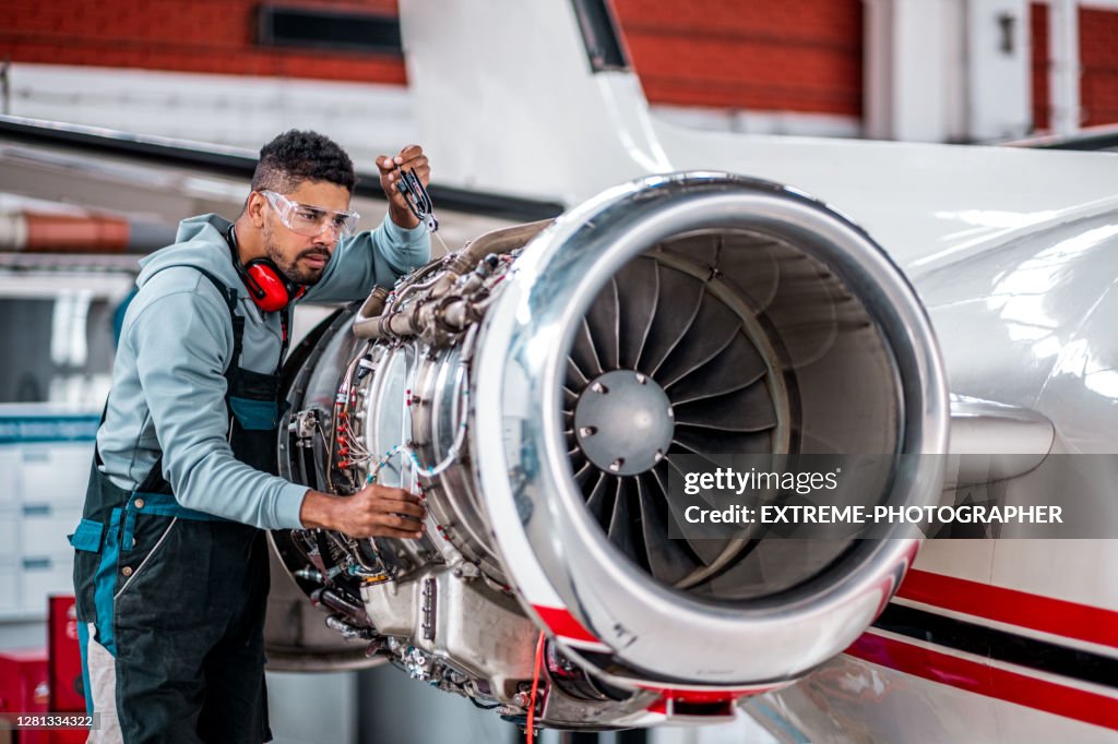 Flugzeugmechaniker prüft Strahltriebwerk des Flugzeugs