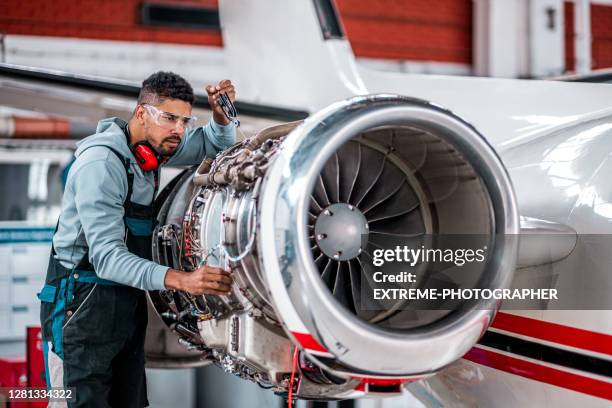 meccanico aeronautico che controlla il motore a reazione dell'aereo - airline service foto e immagini stock