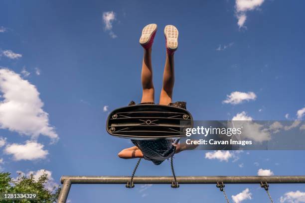 low angle view of young girl swinging against blue sky at playground - denver summer stock pictures, royalty-free photos & images