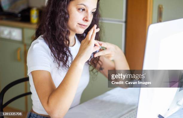 girl speaking sign language on video call - sign stock-fotos und bilder
