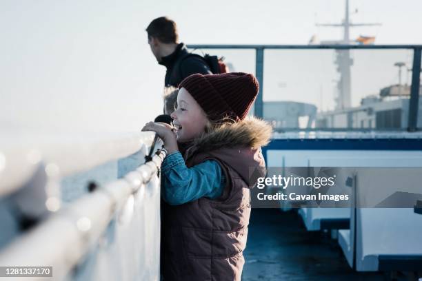 young girl looking excited whilst travelling on a ferry boat - ferry photos et images de collection