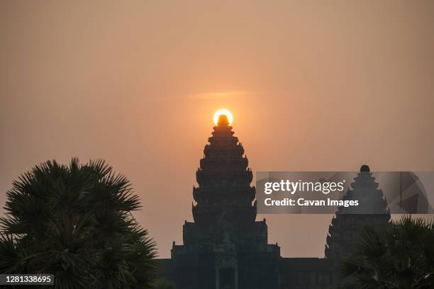 rare shot of sunrise over the middle of the center pagoda / angkor wat - angkor wat bayon stockfoto's en -beelden