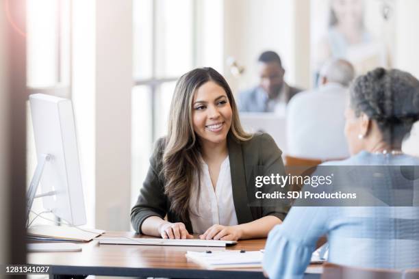 bank employee assisting female customer - credit union stock pictures, royalty-free photos & images