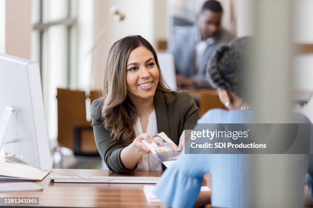 bankmanager bespreekt bankdiensten met klant - investment brochures stockfoto's en -beelden