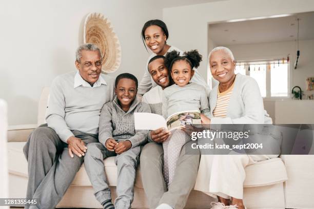 familien-innenporträt - drei generationen im wohnzimmer - legacy stock-fotos und bilder