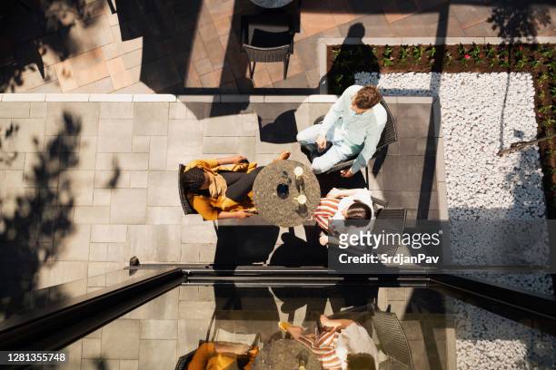 kleine gruppe von freunden mit einem treffen im café-garten, blick auf die oberseite - coffee table from above stock-fotos und bilder