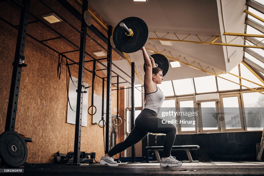 Fit woman training with weights in gym