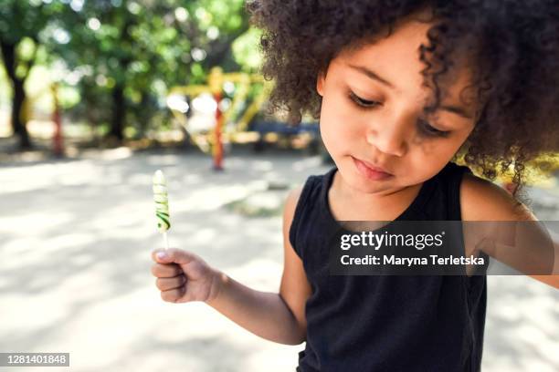 portrait of a cute child girl who eats candy. - lollipops stock pictures, royalty-free photos & images