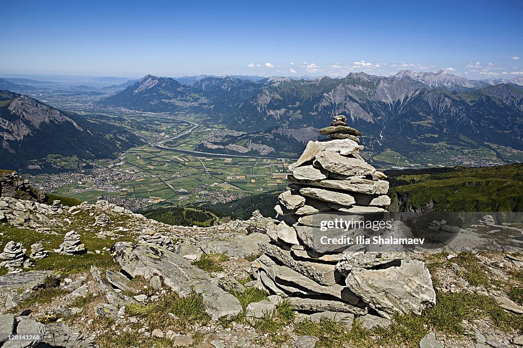 View of stacked stone piles and Rhein valley from Pizol Mountain, Swiss Alps, eastern Switzerland
