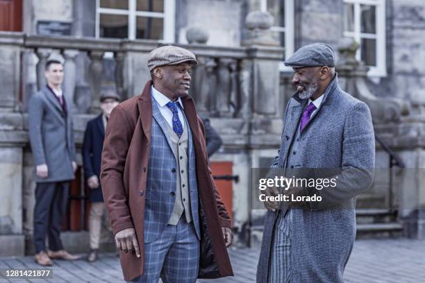 gruppe von vintage gangsterins in einer alten stadt - men costume black and white stock-fotos und bilder