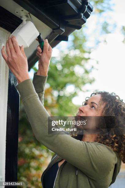homeowner installing security camera - laying driveways stock pictures, royalty-free photos & images