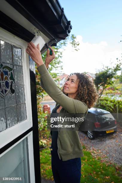 homeowner installing security camera - laying driveways stock pictures, royalty-free photos & images