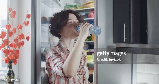 Glass water bottle in refrigerator hi-res stock photography and