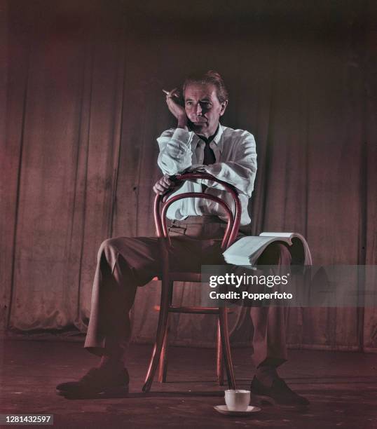 Welsh composer and actor Ivor Novello seated on a chair on stage at a theatre in London in September 1949.