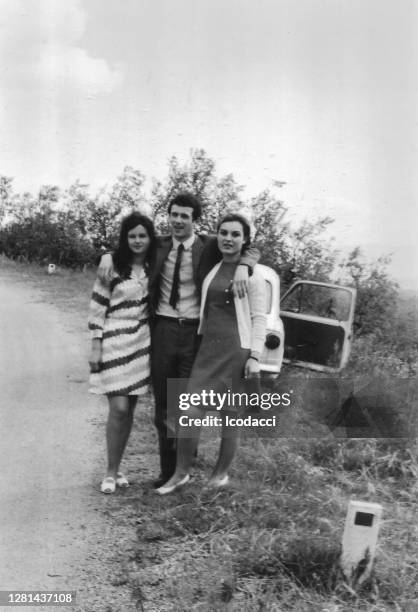 jaren '70 openluchtportret van jonge vrienden die pret op het platteland in zwart-wit hebben. fiat 500 - 1970s fashion stockfoto's en -beelden