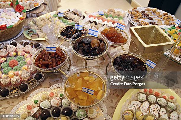 table setting of sweets and dishes with one bowl in the middle and five bowls hanging all filled with various jams for the holiday mimouna, traditional north african jewish celebration held the day after passover. jerusalem. israel. - mimouna stock pictures, royalty-free photos & images