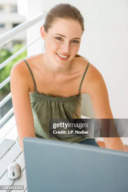 woman working on laptop on the balcony - spaghetti straps stock pictures, royalty-free photos & images