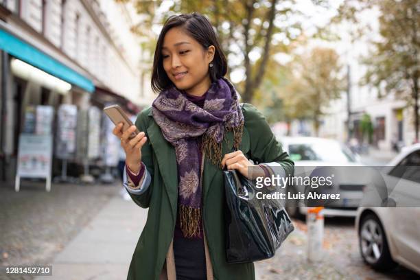 young woman on street using mobile phone - smartphone car stock pictures, royalty-free photos & images