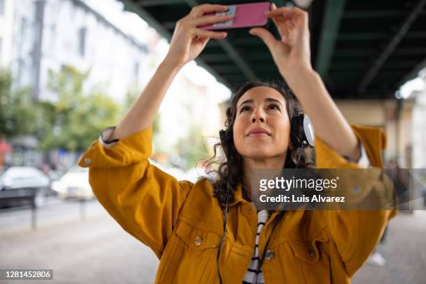 woman taking pictures of bridge from below - photo messaging fotografías e imágenes de stock