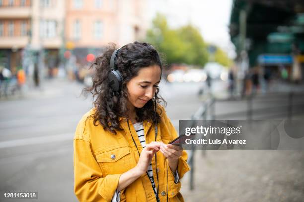 woman listening music from her smart phone - streaming music stock pictures, royalty-free photos & images