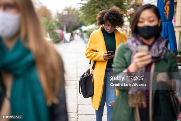 people commuting in the city wearing face masks - hauptverkehrszeit stock-fotos und bilder