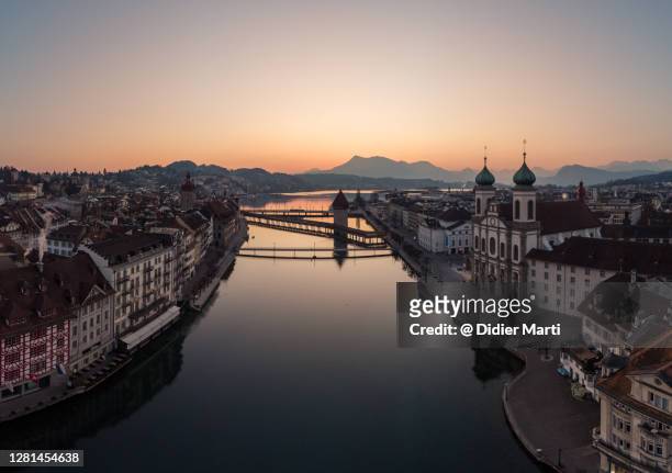 sunset over the lucerne (luzern) old town with the reuss river and the rigi mountain in the background in switzerland - luzern stock-fotos und bilder