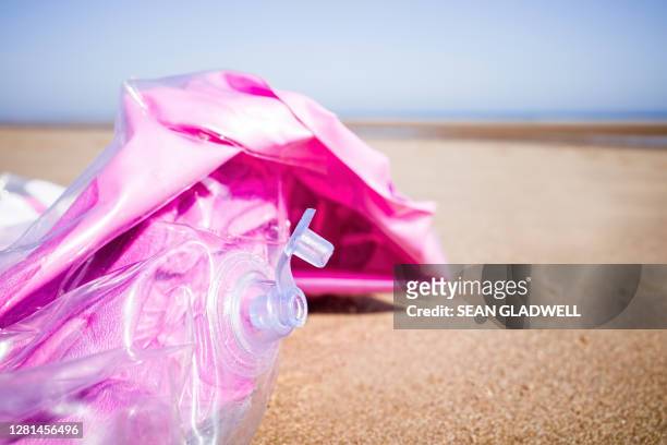 deflated inflatable on beach - deflated stock-fotos und bilder