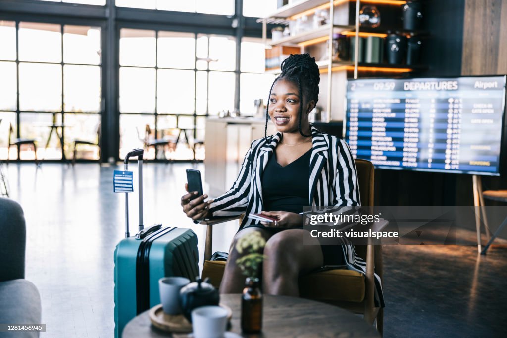 空港のビジネスラウンジでのビデオ通話中の若い黒人女性