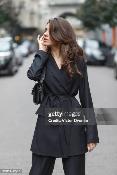 stylish brunette in the black coat on the street - pretty brunette woman fotografías e imágenes de stock