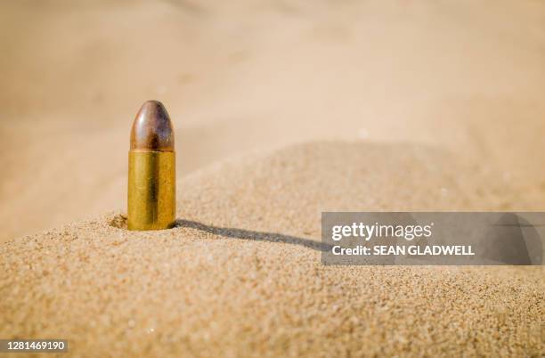 single bullet on sand - terrorism stock pictures, royalty-free photos & images