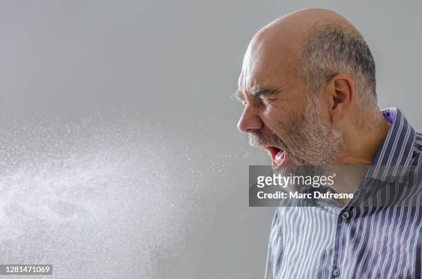 homem espirrando com spray de gota d'água - espirrando - fotografias e filmes do acervo