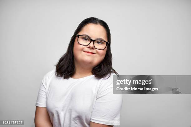 confident disabled young female against white background - downsyndrom stock-fotos und bilder