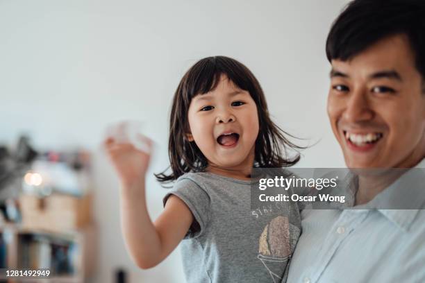 portrait of father and his cute little daughter - waving stock-fotos und bilder