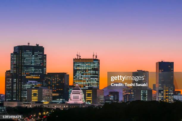 mount fuji appears during the sunset among the high-rise office buildings in nagatacho chiyoda ward tokyo japan. - national diet of japan stock pictures, royalty-free photos & images