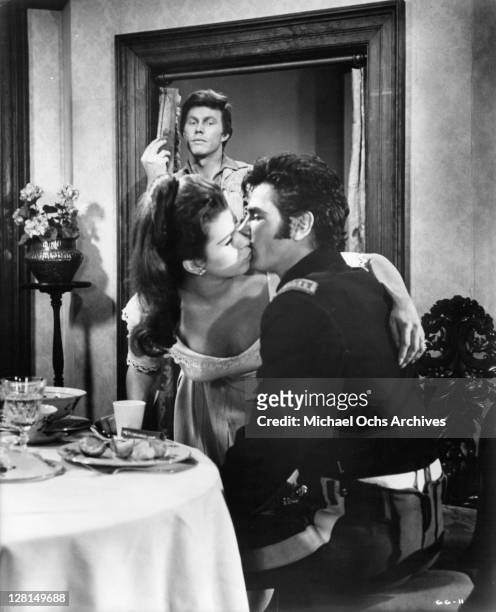 Harve Presnell is surprised when he finds Tom Tryon and Senta Berger kissing in a scene from the film 'The Glory Guys', 1965.