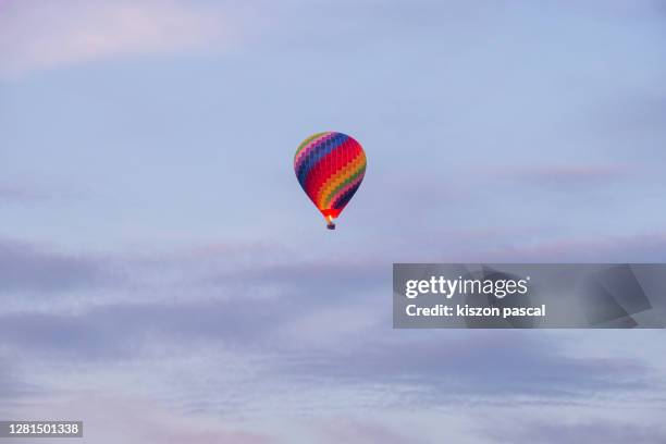 multi-colored hot air ballon flying in the sky . - vang vieng balloon stockfoto's en -beelden