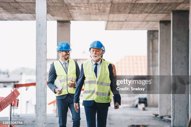 three architects visiting building site. - construction site visit stock pictures, royalty-free photos & images