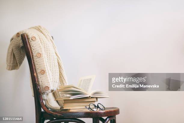 open book on old wooden chair - cardigan stock pictures, royalty-free photos & images