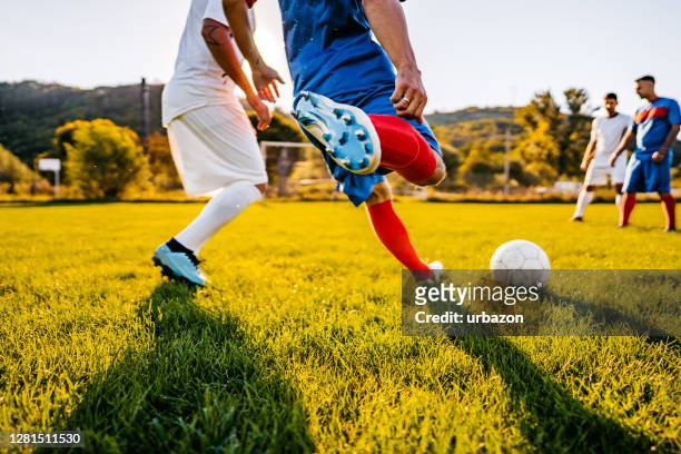 jugadores de fútbol jugando al fútbol - liga de fútbol fotografías e imágenes de stock